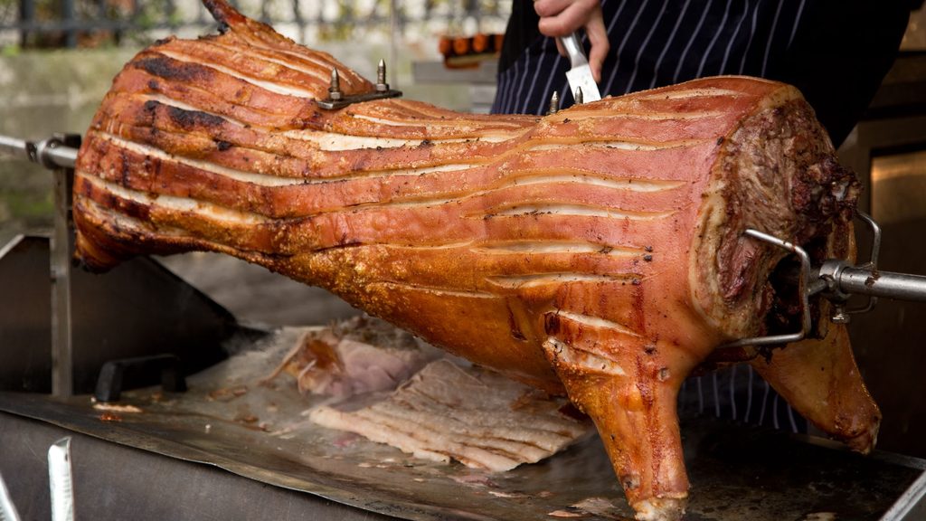 Spit Braai Centurion - whole pig roasting on a spit braai and being carved at an outdoor function Spit Braai Centurion - whole pig roasting on a spit braai and being carved at an outdoor function
